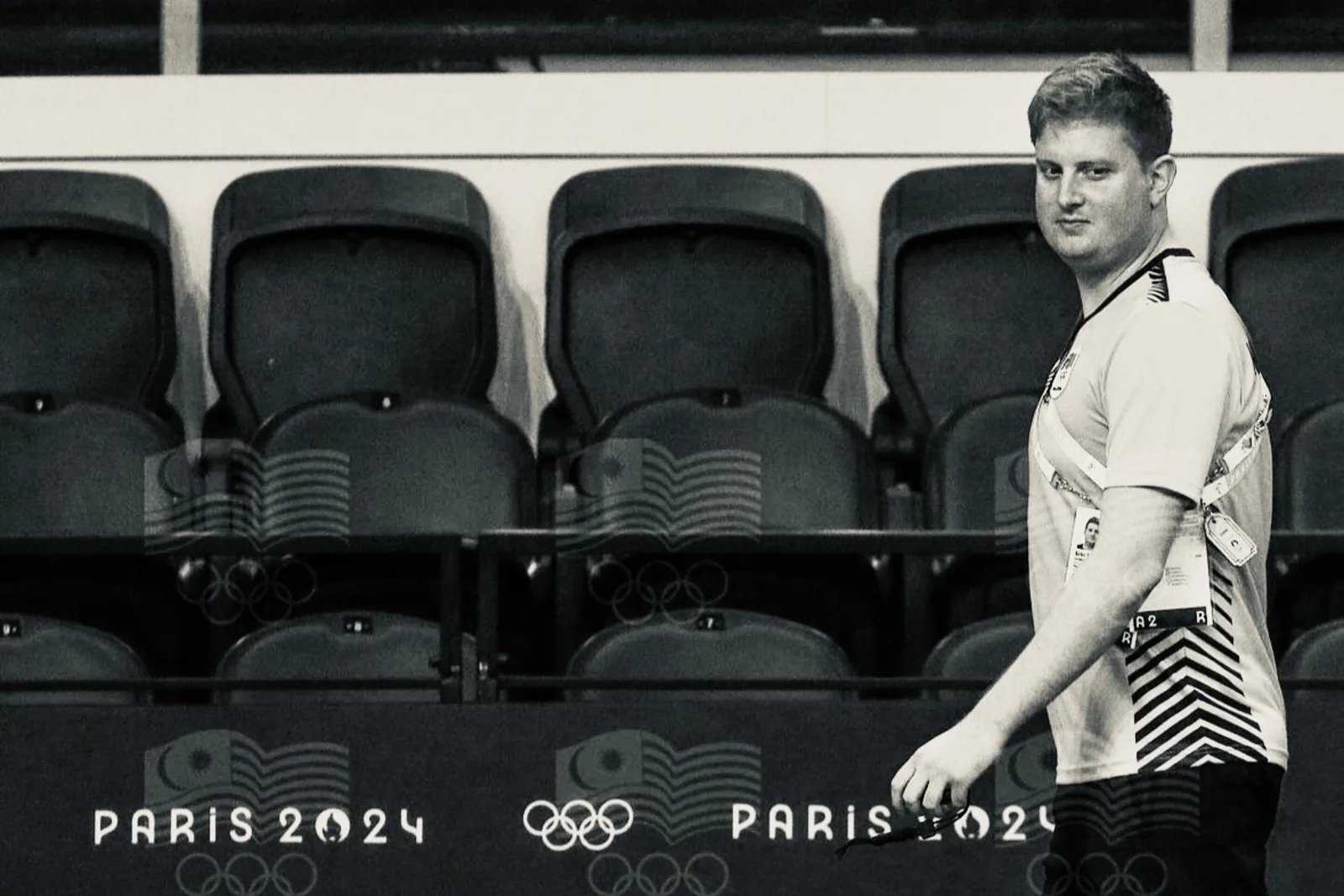 Un entrenador en el borde de la piscina en los Juegos Olímpicos de París 2024, con la acreditación al cuello.
